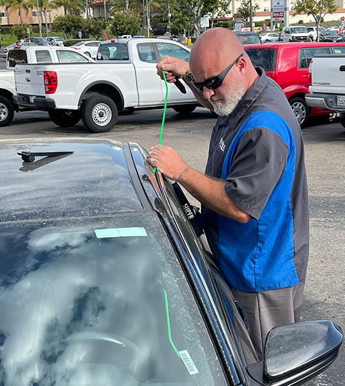 Using a longarm tool and inflatable wedge to safely unlock a car door.